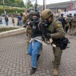 U.S. Border Patrol agent (right) and an ICE officer detain a protester outside the ICE facility on October 4, 2025 in Portland, Oregon