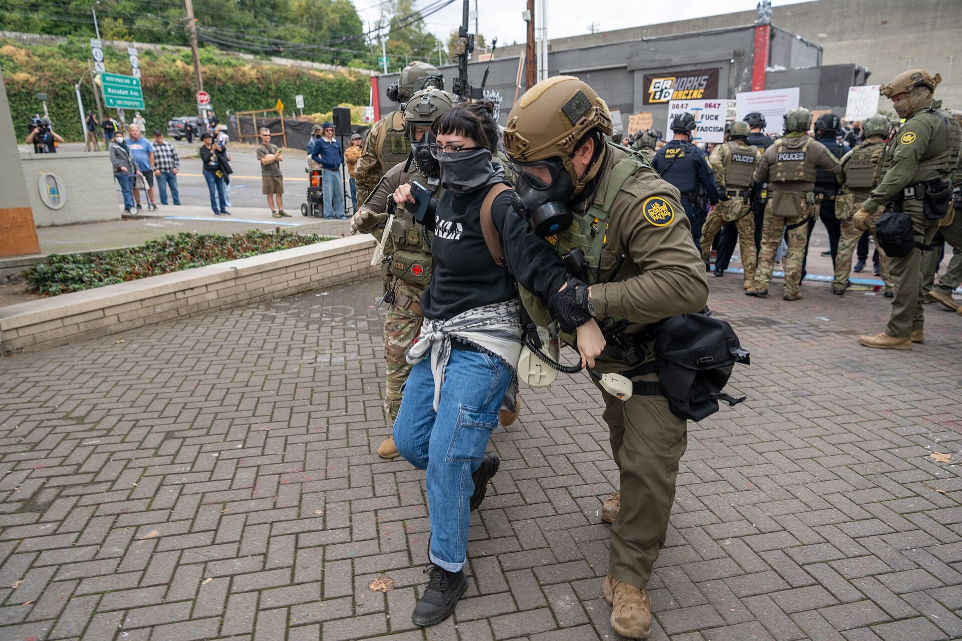 U.S. Border Patrol agent (right) and an ICE officer detain a protester outside the ICE facility on October 4, 2025 in Portland, Oregon