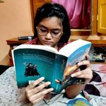 A teenage girl reading Harry Potter and the Goblet of Fire